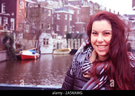 I Capelli rossi ragazza caucasica in autunno o inverno vestito in abiti caldi per il freddo tra le strade di Amsterdam, Olanda, Paesi Bassi Foto Stock