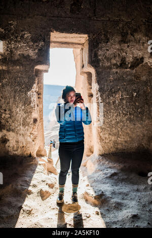 Donna prendendo fotografia nel monastero di Selime, Göreme, Cappadocia, Nevsehir, Turchia Foto Stock