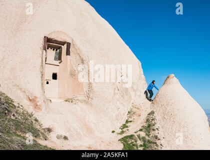 Donna di esplorare il Castello di Uchisar, Göreme, Cappadocia, Nevsehir, Turchia Foto Stock