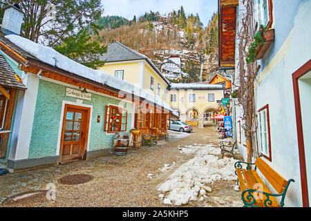 HALLSTATT, Austria - 25 febbraio 2019: le vecchie case colorate di Badergraben street con una vista sul Muhlbach cascata, che scorre dal ripido ro Foto Stock