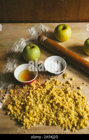 Serie di fotografia come fare un mele crumble , dagli ingredienti alla fine torta, ambiente rustico, gli ingredienti e gli strumenti per preparare t Foto Stock