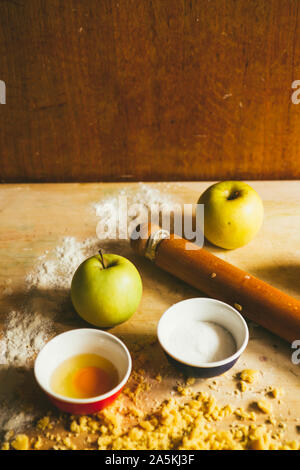 Serie di fotografia come fare un mele crumble , dagli ingredienti alla fine torta, ambiente rustico, gli ingredienti e gli strumenti per preparare t Foto Stock