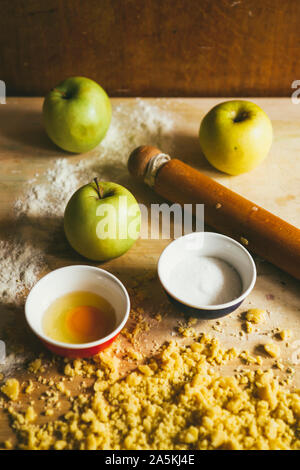 Serie di fotografia come fare un mele crumble , dagli ingredienti alla fine torta, ambiente rustico, gli ingredienti e gli strumenti per preparare t Foto Stock