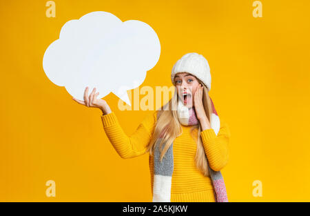 Schocked ragazza con bolla di comunicazione nella sua mano Foto Stock