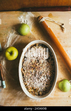 Serie di fotografia come fare un mele crumble , dagli ingredienti alla fine torta, ambiente rustico, finitura incrostato cuocere in forno su una rustica Foto Stock