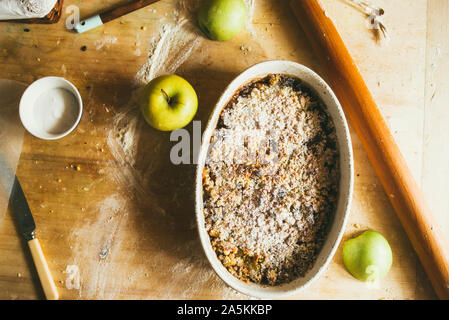 Serie di fotografia come fare un mele crumble , dagli ingredienti alla fine torta, ambiente rustico, finitura incrostato cuocere in forno su una rustica Foto Stock