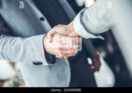 Startupers maschio lavorando insieme a Office handshake permanente di close-up Foto Stock