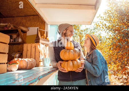 Halloween Preparaton concetto. Coppia giovane decorare casa con zucche guardando ogni altra felice Foto Stock