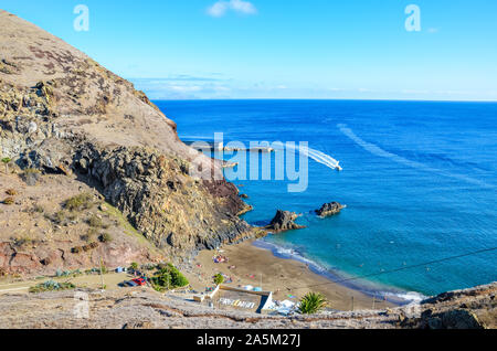 Bella Prainha Beach dall' Oceano Atlantico a Madeira, Portogallo. Circondato dal paesaggio vulcanico e scogliere, la gente sulla spiaggia, giornata di sole. Traduzione di segno: Prainha - piccola spiaggia in portoghese. Foto Stock