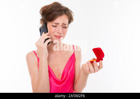Ritratto di un sconvolto sposa con un anello di nozze nelle sue mani, una ragazza invecchiato telefonare e pianto Foto Stock