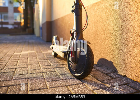 Lo scooter elettrico sullo sfondo di una parete Foto Stock