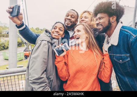 Gli amici di trarre il meglio dalla pioggia e cattivo tempo Foto Stock