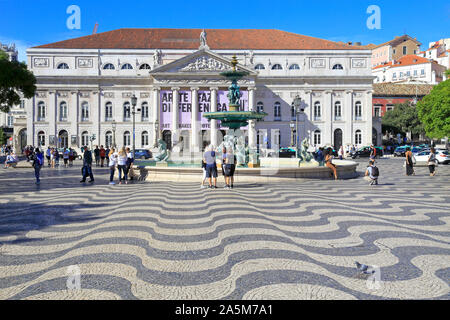 I turisti dalla fontana di fronte al Teatro Nazionale D. Maria II in piazza Rossio, Lisbona, Portogallo. Foto Stock