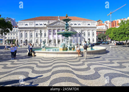 I turisti dalla fontana di fronte al Teatro Nazionale D. Maria II in piazza Rossio, Lisbona, Portogallo. Foto Stock