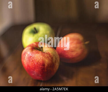 Rosso e giallo di mele con gocce di acqua su un tavolo in legno ancora vita Foto Stock