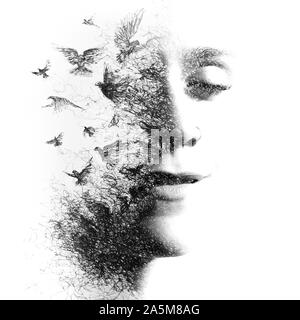 Paintography. La doppia esposizione ritratto di una giovane donna che scompare in particelle che si trasformano in uccelli in volo, disegnati a mano, in bianco e nero Foto Stock