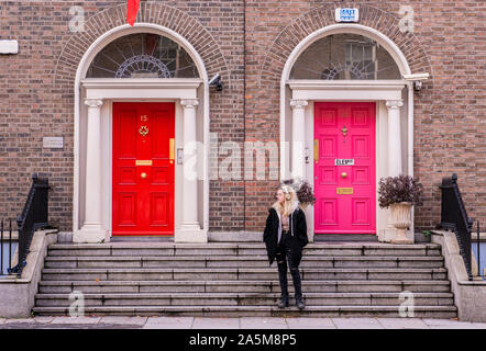 Giovane donna sulla scalinata di fronte all edificio residenziale, Dublino, Irlanda Foto Stock