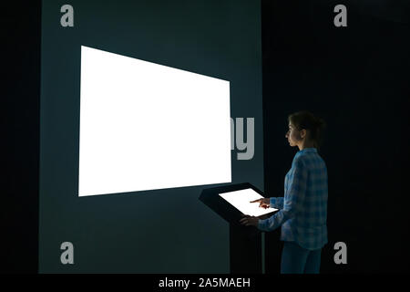 Donna che guarda a vuoto bianco grande parete interattiva display - mockup immagine Foto Stock
