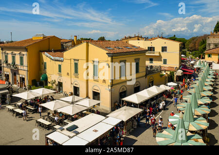 Vista in elevazione di una strada nella famosa città di Pisa con un McDonald's ristorante fast food e turisti dello shopping al negozio di souvenir si spegne, Toscana, Italia Foto Stock