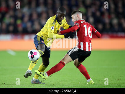 Dell'Arsenal Nicolas Pepe (sinistra) e Sheffield Regno di Oliver Norwood battaglia per la palla durante il match di Premier League a Bramall Lane, Sheffield. Foto Stock