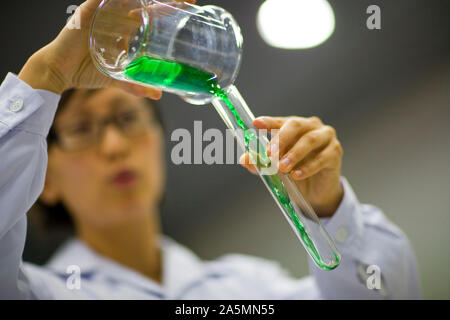 Il liquido viene versato in una provetta. Foto Stock