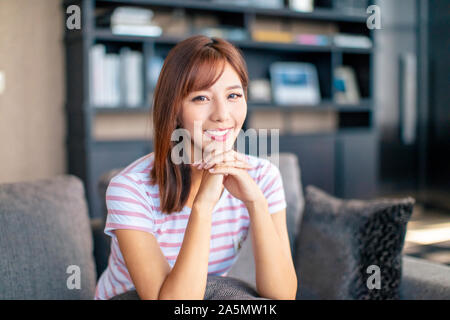 Bella giovane donna sorridente nel soggiorno Foto Stock