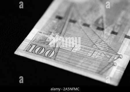 Un centinaio di dollari di Hong Kong banconota su sfondo scuro vicino. In bianco e nero Foto Stock