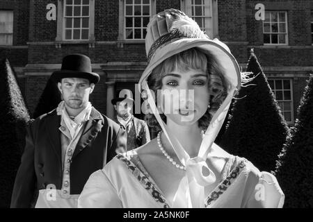 Bel maschio giovane e bella donna vestito in abiti d'epoca in piedi al di fuori della casa nobiliare. Foto Stock