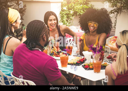 Gruppo di amici gustando pasti e divertimento all'aperto Foto Stock