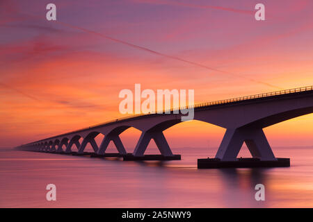 Colorato tramonto sul ponte di Zeeland, parco nazionale di Oosterschelde, Paesi Bassi Foto Stock