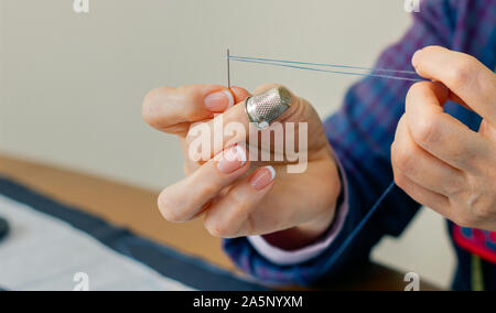 Senior sarta femmina filettatura un ago Foto Stock