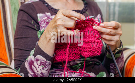 Le mani della donna la tessitura di un maglione di lana Foto Stock