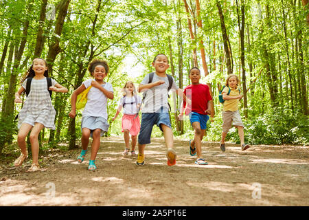 Gruppo di bambini con zaino fa una gara in natura in estate Foto Stock