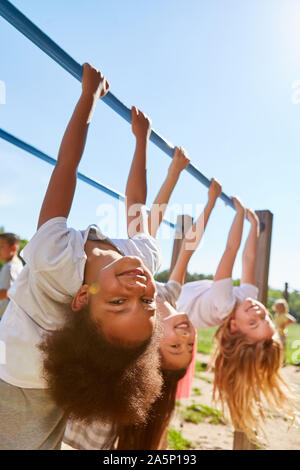 Le tre ragazze fare ginnastica insieme su un telaio di arrampicata Foto Stock