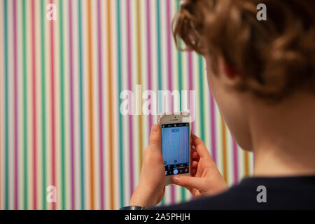 Un ragazzo prende una foto di 'Peana, 1973' in una retrospettiva di lavori da parte di British op-art specialista Bridget Riley apre presso la Hayward Gallery nella Southbank. Foto Stock