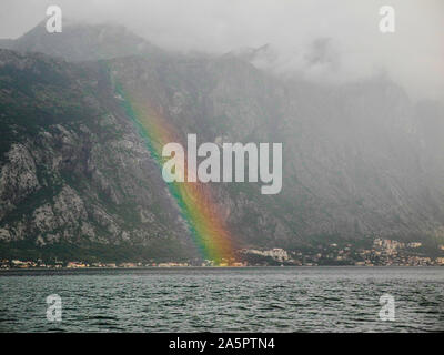 Bright rainbow sulla Baia di Kotor, Montenegro. Nebbioso giorno di pioggia in estate. Foto Stock