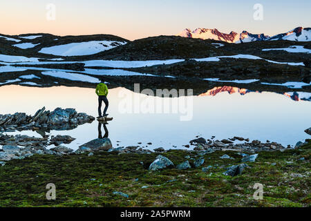 Persona in piedi dal lago in montagna Foto Stock