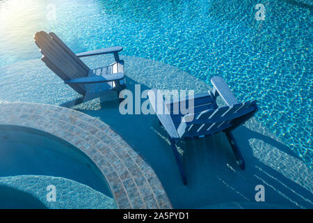 Due poltrone Adirondack in piscina Foto Stock