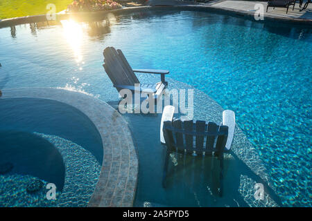 Due poltrone Adirondack in piscina Foto Stock