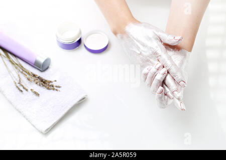 Silver Mask per le mani. La donna si prende cura per la pelle della mano Foto Stock