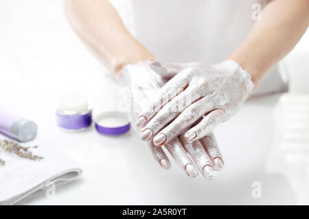 Spa a mano. La donna mette una maschera per la pelle della mano. Mano la cura della pelle. Foto Stock