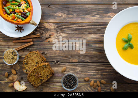 In autunno la zucca spice. Zuppa di zucca con foglie di basilico e zucca cotta al forno con verdure, carota, fagioli fagioli bianchi e i duroni. Spezie di zucca fette di torta. Parte superiore Foto Stock