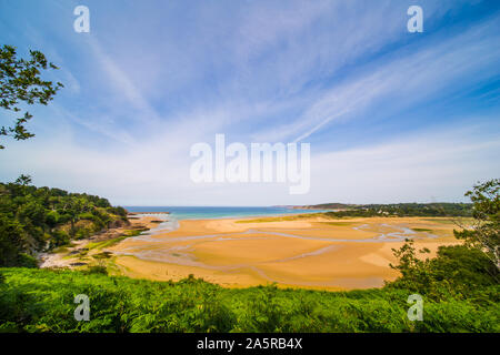 La bassa marea e lo streaming di acqua nella spiaggia di sabbia dorata in Sable d'o in una giornata di sole in Bretagne Francia Foto Stock