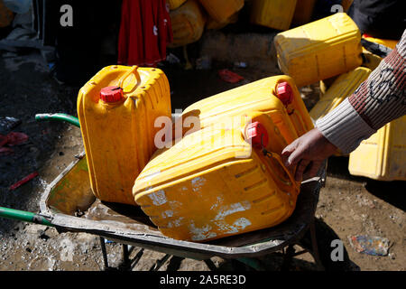 Sanaa, Yemen. 22 ottobre, 2019. Un uomo mette le bottiglie su una carriola dopo che egli aveva riempito con acqua da una carità tocca in Sanaa, Yemen, ad Ottobre 22, 2019. Credito: Mohammed Mohammed/Xinhua/Alamy Live News Foto Stock