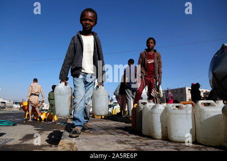 Sanaa, Yemen. 22 ottobre, 2019. Un bambino porta bottiglie riempite con acqua da una carità tocca in Sanaa, Yemen, ad Ottobre 22, 2019. Credito: Mohammed Mohammed/Xinhua/Alamy Live News Foto Stock