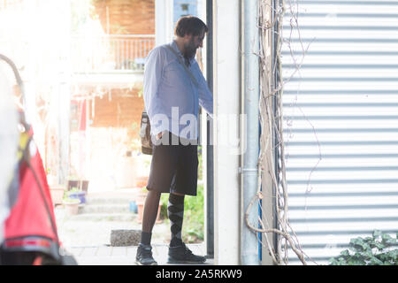 Uomo vecchio con gamba protesico coming home Foto Stock