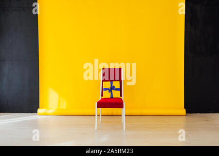 Sedia rossa all'interno della camera con uno sfondo giallo Foto Stock