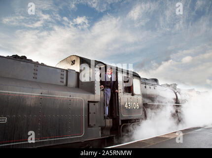 Vintage, UK locomotiva a vapore 43106 in attesa della partenza dalla piattaforma a Kidderminster Severn Valley Railway Station, treno a vapore conducente si affaccia in cabina. Foto Stock