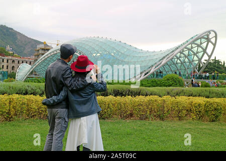 Paio di godere di una splendida vista del Ponte di Pace, un eccezionale punto di riferimento di Tbilisi, capitale della Georgia Foto Stock