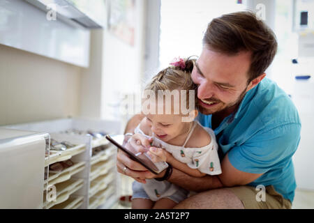 Felice gioiosa giovane padre con la sua piccola figlia. Padre e ragazzino divertendosi Foto Stock